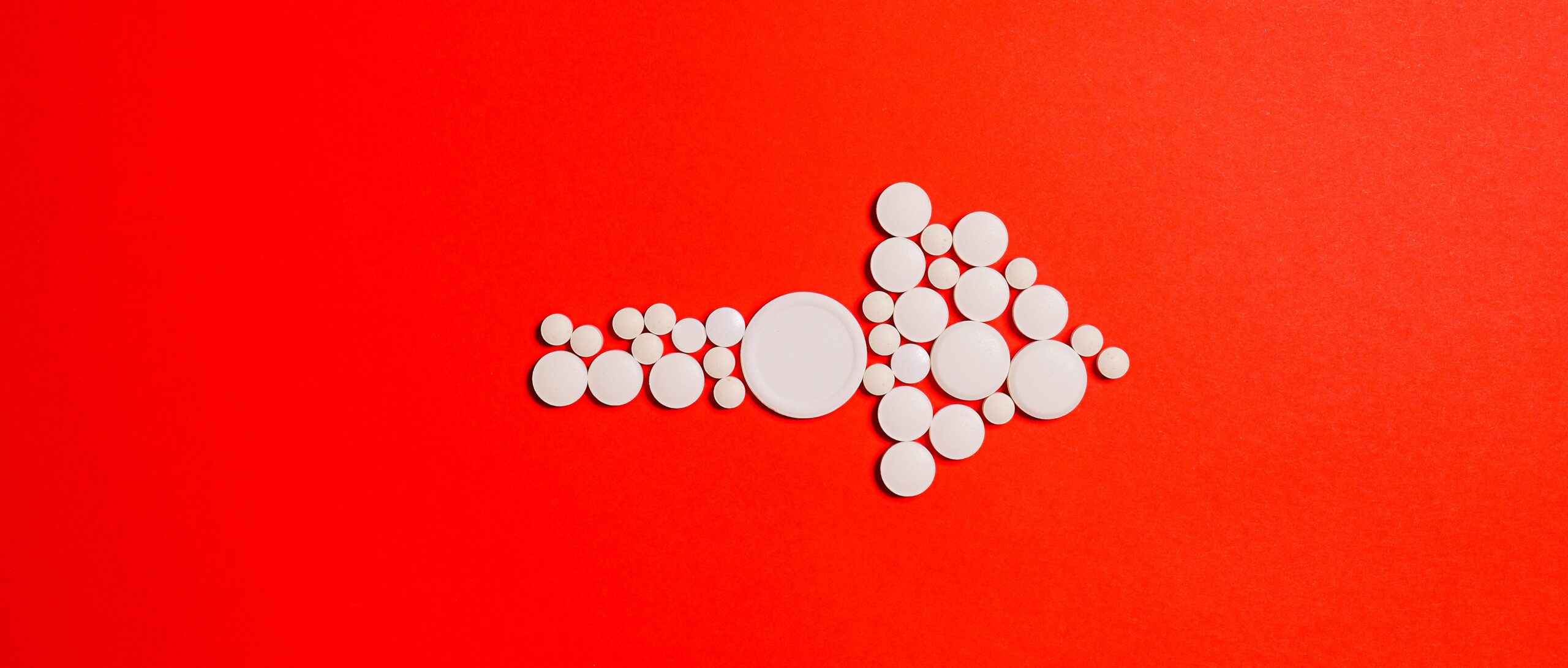 white-round-medication-pill-on-red-surface-3683087